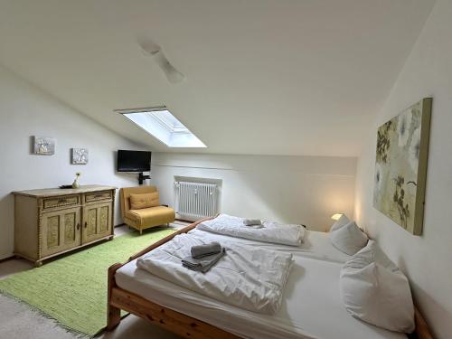 ein Schlafzimmer mit 2 Betten und einem Stuhl darin in der Unterkunft Gschwendtnerhof App13 Lincke in Aschau im Chiemgau