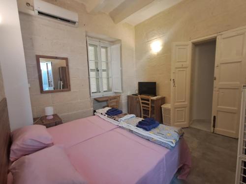 a bedroom with a pink bed and a mirror at 63, Casa Falzon in Rabat