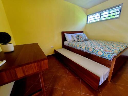 Pura Vida - Villa Lisa في باريتا: غرفة نوم صغيرة بها سرير ومكتب