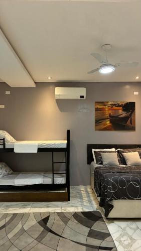 um quarto com duas camas e um ventilador de teto em SR Casa de férias Astúrias no Guarujá