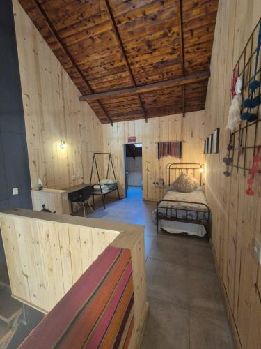 a bedroom with a bed in a wooden room at Chapa atrás - SalePatagonia in San Martín de los Andes