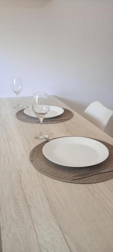 a table with two plates and wine glasses on it at Atenea in Chivilcoy