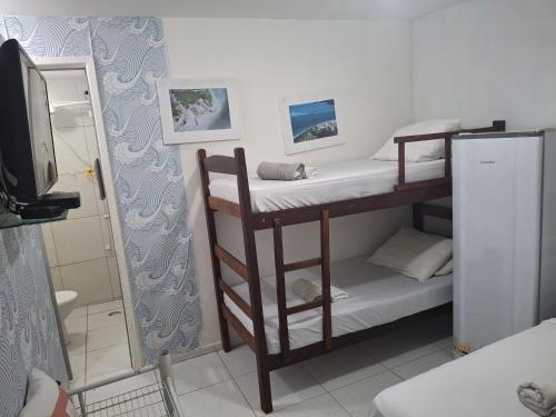 イタマラカーにあるPousada fbi - Flat Beach Itamaracáの二段ベッド2台とテレビのある部屋