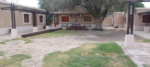 an empty yard with a house with a tree in it at El Aura l Complejo de apartamentos amoblados in Villa Krause