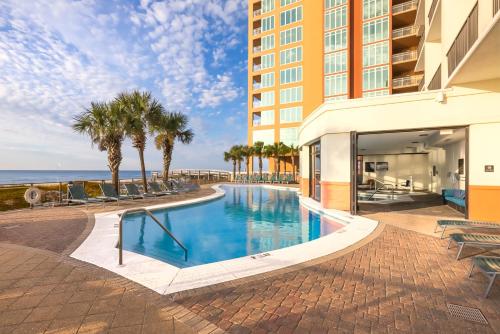 a swimming pool in front of a building with the ocean at Hampton Inn & Suites - Orange Beach in Orange Beach