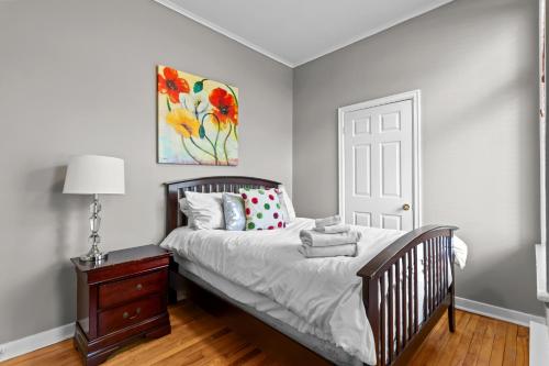 een slaapkamer met een wieg en een schilderij aan de muur bij Cozy 2BR Loft Parking Wi-Fi in St. John's