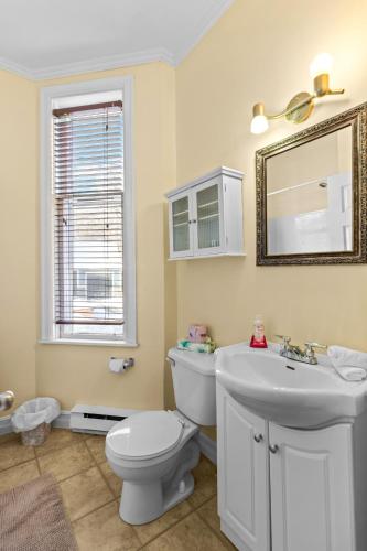 a bathroom with a toilet and a sink and a mirror at Cozy 2BR Loft Parking Wi-Fi in St. John's