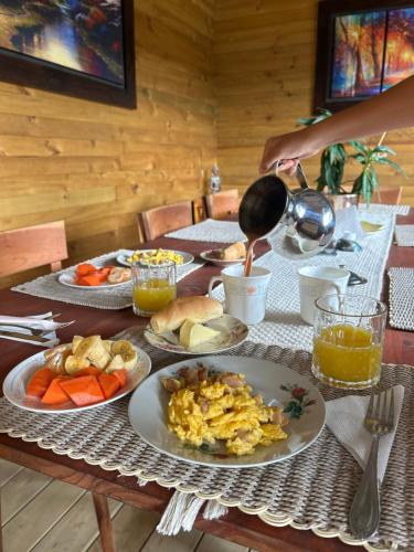 a table with plates of breakfast food on it at Glamping Entre Mangos in La Mesa