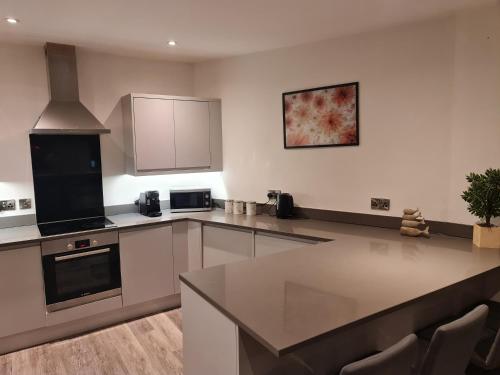 a kitchen with white cabinets and a counter top at City Centre-Contactors-Professionals-Luxury Apartment in Nottingham