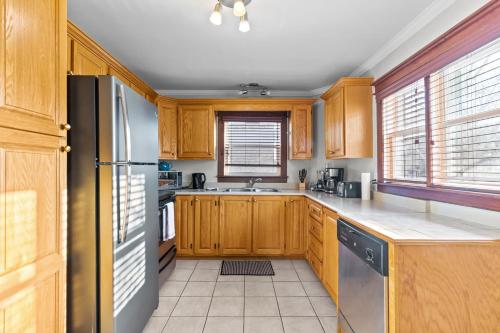 een keuken met houten kasten en een roestvrijstalen koelkast bij Spacious 3BR Parking Pet-Friendly in St. John's