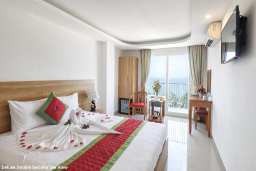 a bedroom with a bed and a view of the ocean at Siren Flower Hotel in Nha Trang