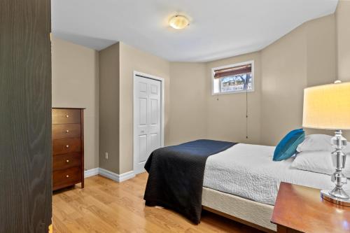 een slaapkamer met een bed, een tafel en een raam bij Modern 2BR Wi-Fi TV Off-Street in St. John's