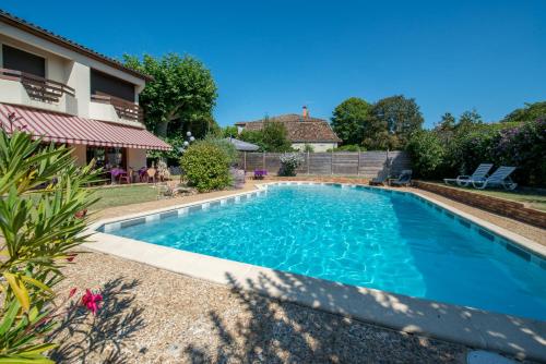 a swimming pool in the backyard of a house at L'Etape Gasconne in Allemans-du-Dropt