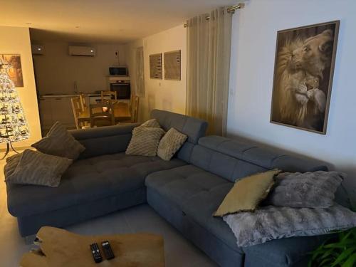 ein Wohnzimmer mit einer blauen Couch mit Kissen in der Unterkunft Gîtes Vosges, Spa, Sauna & Piscine in Moyenmoutier