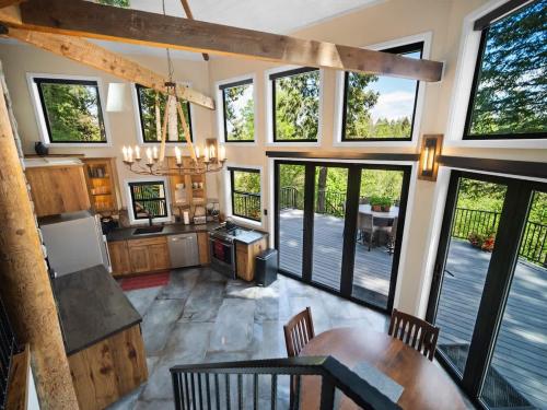 een keuken met grote ramen en een eettafel bij Adullam Rustic Cabin in Colbert