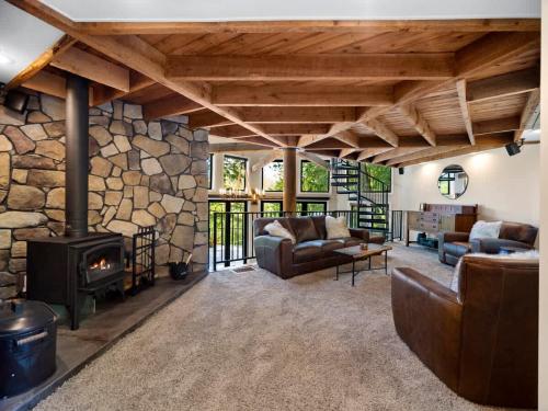 een woonkamer met banken en een stenen open haard bij Adullam Rustic Cabin in Colbert