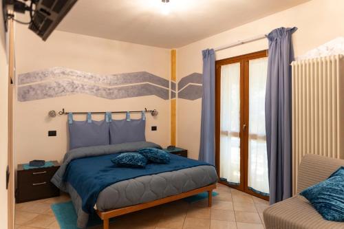 a bedroom with a bed with blue pillows at La Casa Del Grillo 1 in Aosta