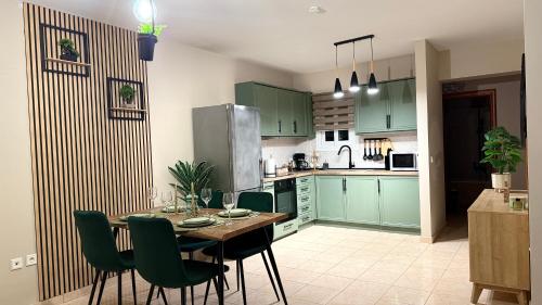 een keuken met groene kasten en een tafel en stoelen bij Angelo Maison in Thessaloniki