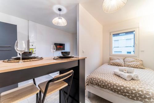 a bedroom with a bed and a desk with glasses at L'Odyssée - Mercure - Gare - Wifi - Netflix in Tourcoing