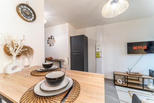 a kitchen with a wooden table with two dishes on it at L'Odyssée - Mercure - Gare - Wifi - Netflix in Tourcoing