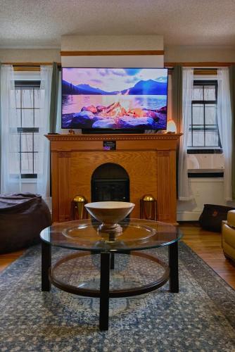 a living room with a tv on top of a fireplace at Sweet Home - Zoller Stays in Long Island City