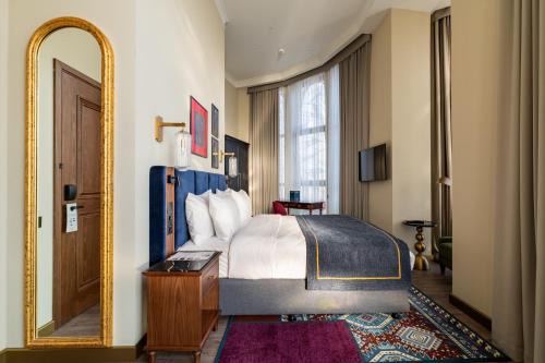 Un dormitorio con una cama y un espejo grande. en Hotel Indigo Batumi - Old Town by IHG, en Batumi
