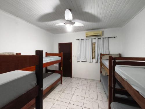 um quarto com 3 beliches e uma ventoinha de tecto em Pousada Adventure em Chapada dos Guimarães