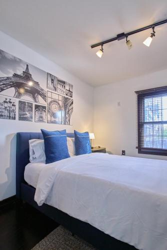 a bedroom with a large white bed with blue pillows at Sweet Home - Zoller Stays in Long Island City
