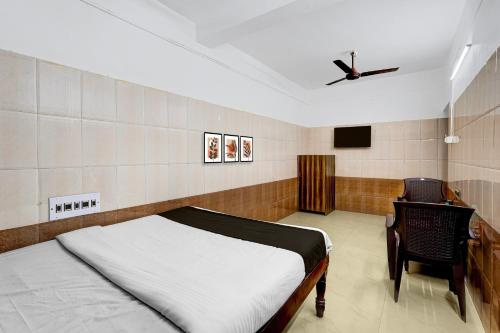 um quarto com uma cama e um ventilador de teto em Hotel O Rock Beachview Pondicherry Formerly Varsha Residency em Pondicherry