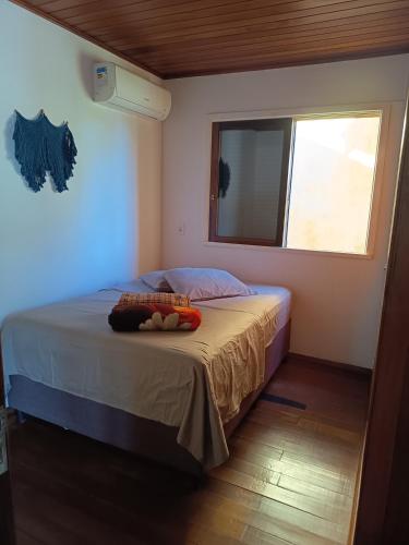 a small bedroom with a bed with a window at Lorena'Haus in Bombinhas