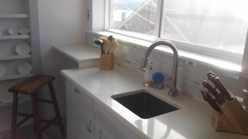 a kitchen counter with a sink and a window at Hummingbird downtown water view apartment in Ketchikan