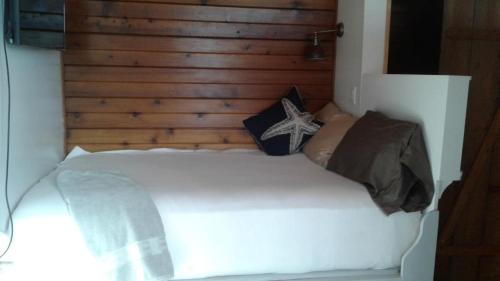 a bedroom with a white bed with a wooden headboard at Hummingbird downtown water view apartment in Ketchikan
