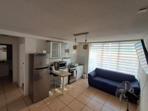 a kitchen with a blue couch and a refrigerator at Sector Norte 1 Dormitorio in Antofagasta
