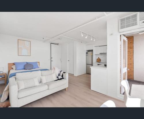 ein weißes Schlafzimmer mit Bett und Küche in der Unterkunft Bondi Beach Studio with an ocean view in Sydney