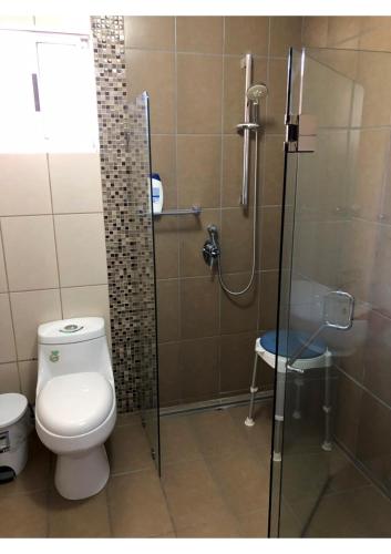 a bathroom with a toilet and a glass shower at casa la luz Orotina in Orotina