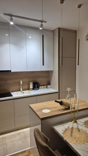 uma cozinha com armários brancos e uma bancada em Apartman VIS em Arandjelovac