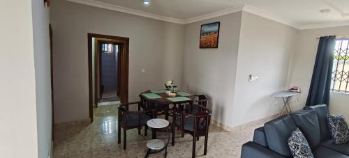 a living room with a table and chairs and a couch at Purple Springs Elmina #1 in Esamang