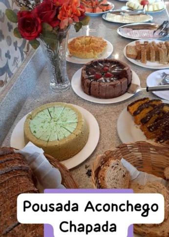 アウト・パライーゾ・デ・ゴイアスにあるPOUSADA ACONCHEGO CHAPADAの皿の上にケーキやパイがいっぱい並んだテーブル