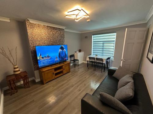 a living room with a couch and a flat screen tv at City Centre 3 Bedrooms House with 2 Free Parking in Nottingham