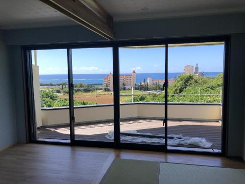 a room with a large glass door with a view at Villa resort -悠- in Miyakojima