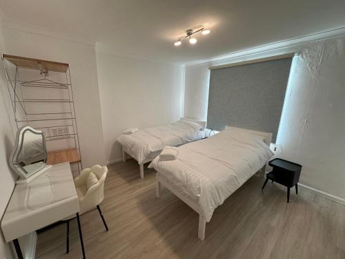 a bedroom with two beds and a desk and a mirror at City Centre 3 Bedrooms House with 2 Free Parking in Nottingham