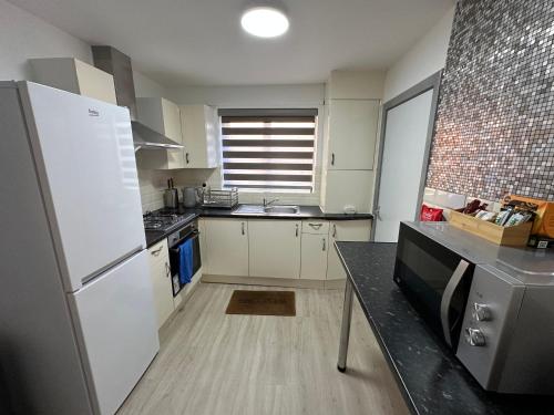 a kitchen with a white refrigerator and a counter top at City Centre 3 Bedrooms House with 2 Free Parking in Nottingham