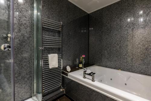 a bathroom with a bath tub and a shower at The Hawk & Buckle Inn in Llannefydd