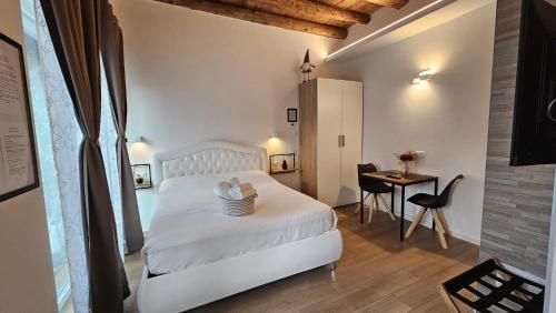 a white bedroom with a white bed and a table at Junior Suite, Villa Joy Verona, Romantic, with garden, elegant living room, near the city center in Verona