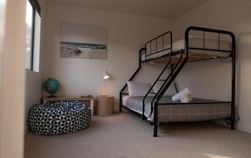 een slaapkamer met twee stapelbedden in een kamer bij House Peron - Bayside Luxury in St Helens