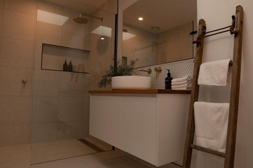 een badkamer met een witte wastafel en een douche bij House Peron - Bayside Luxury in St Helens