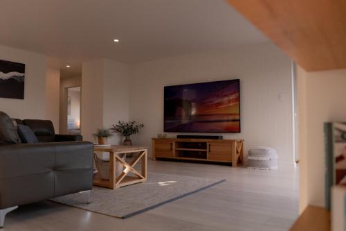 a living room with a flat screen tv on a wall at House Peron - Bayside Luxury in St Helens