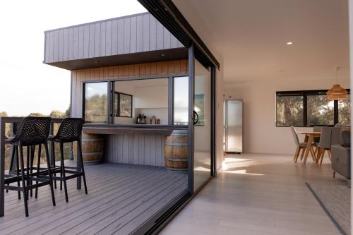 a kitchen and living room with a bar on a deck at House Peron - Bayside Luxury in St Helens
