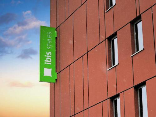 ein grünes Schild an der Seite eines Gebäudes in der Unterkunft ibis Styles Warszawa Airport in Warschau
