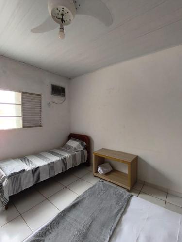 a room with two beds and a table and a window at Adventure Casa de Temporada in Chapada dos Guimarães